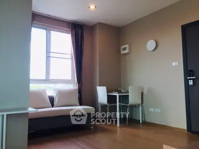 Modern living room with natural light and cozy seating area in a stylish apartment.