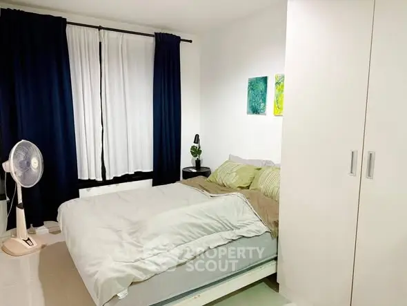 Cozy bedroom with modern decor and ample natural light.