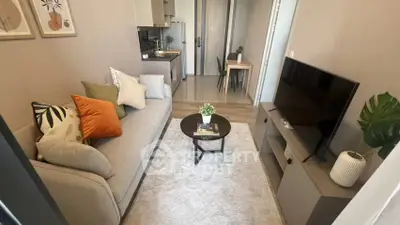 Modern living room with cozy sofa, stylish decor, and open kitchen layout in a contemporary apartment.