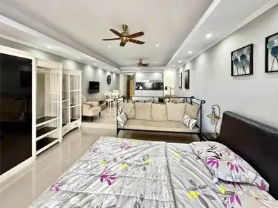 Spacious open-plan living room with modern decor and ceiling fans, perfect for comfortable living.