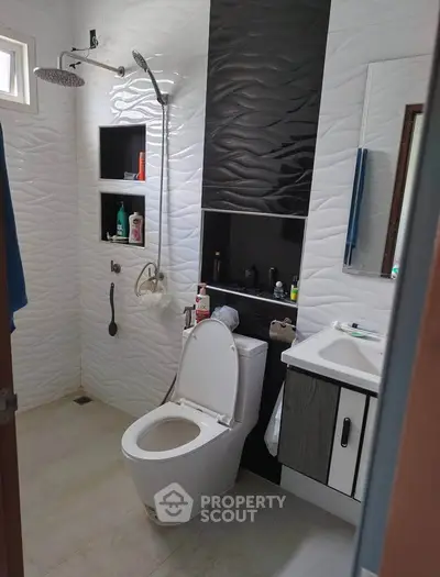 Modern bathroom with sleek fixtures and stylish black and white tile design.