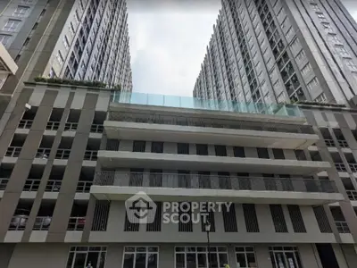 Modern high-rise building exterior with sleek design and glass balconies.