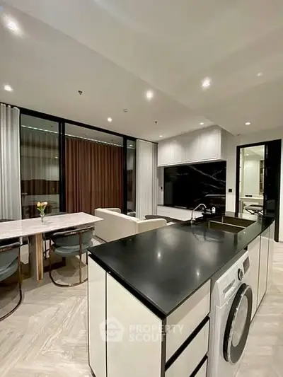 Modern open-plan kitchen and living area with sleek design and integrated appliances.