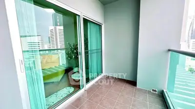 Spacious balcony with city view and sliding glass doors in modern apartment.