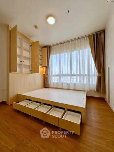 Modern bedroom with built-in storage and large window offering natural light