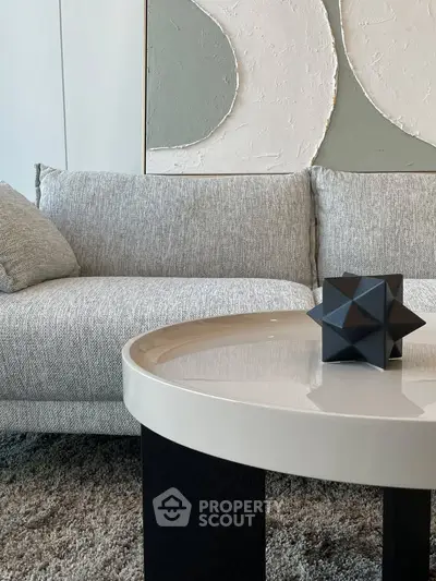 Modern living room with stylish sofa and geometric decor on sleek coffee table.