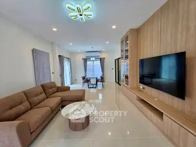 Spacious modern living room with elegant decor and large TV, perfect for relaxation.