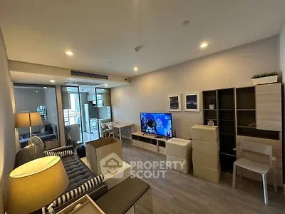 Modern living room with stylish furniture and TV, featuring a cozy ambiance and contemporary design.
