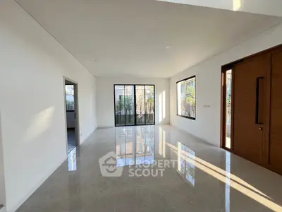 Spacious modern living room with large windows and glossy tile flooring