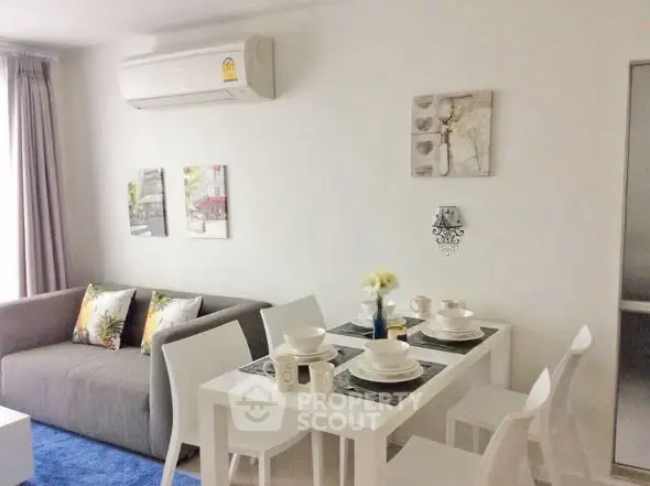 Modern living room with dining area, featuring sleek furniture and stylish decor.