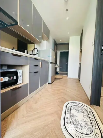 Modern kitchen with sleek cabinets and wood flooring in a stylish apartment.