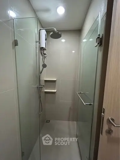 Modern bathroom with glass shower enclosure and sleek fixtures