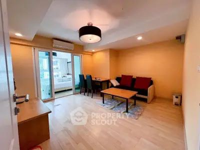 Spacious living room with modern decor and view into cozy bedroom