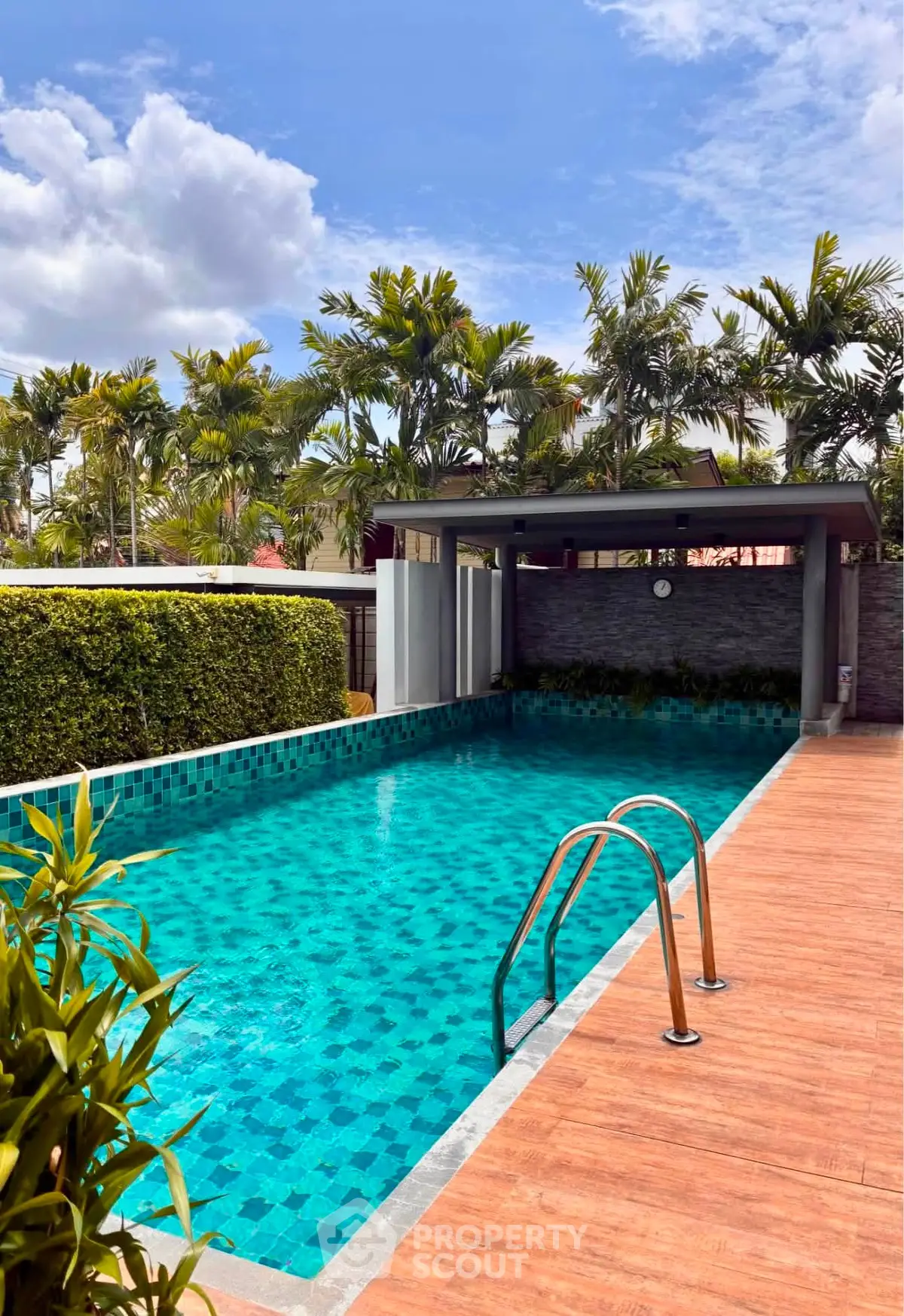Luxurious outdoor pool with lush greenery and modern design, perfect for relaxation and leisure.