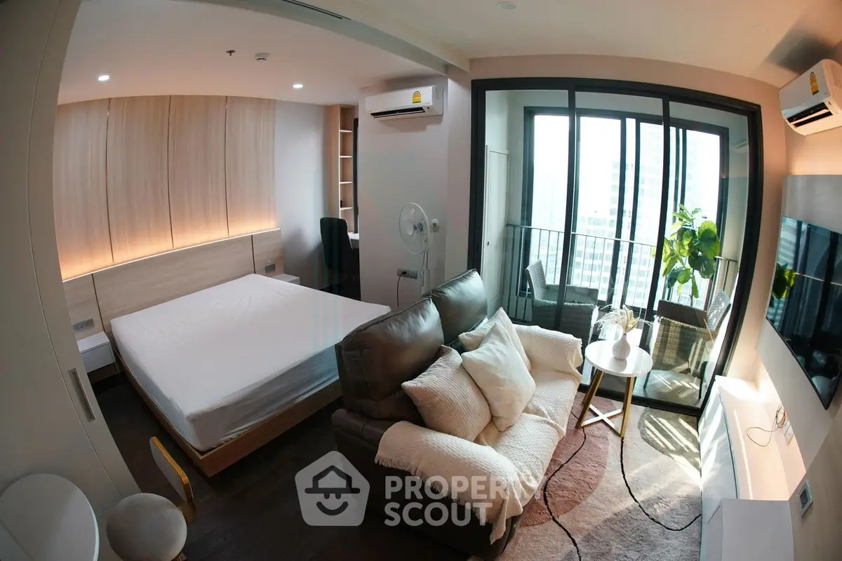 Modern studio apartment with balcony and city view, featuring cozy living area and stylish bedroom.