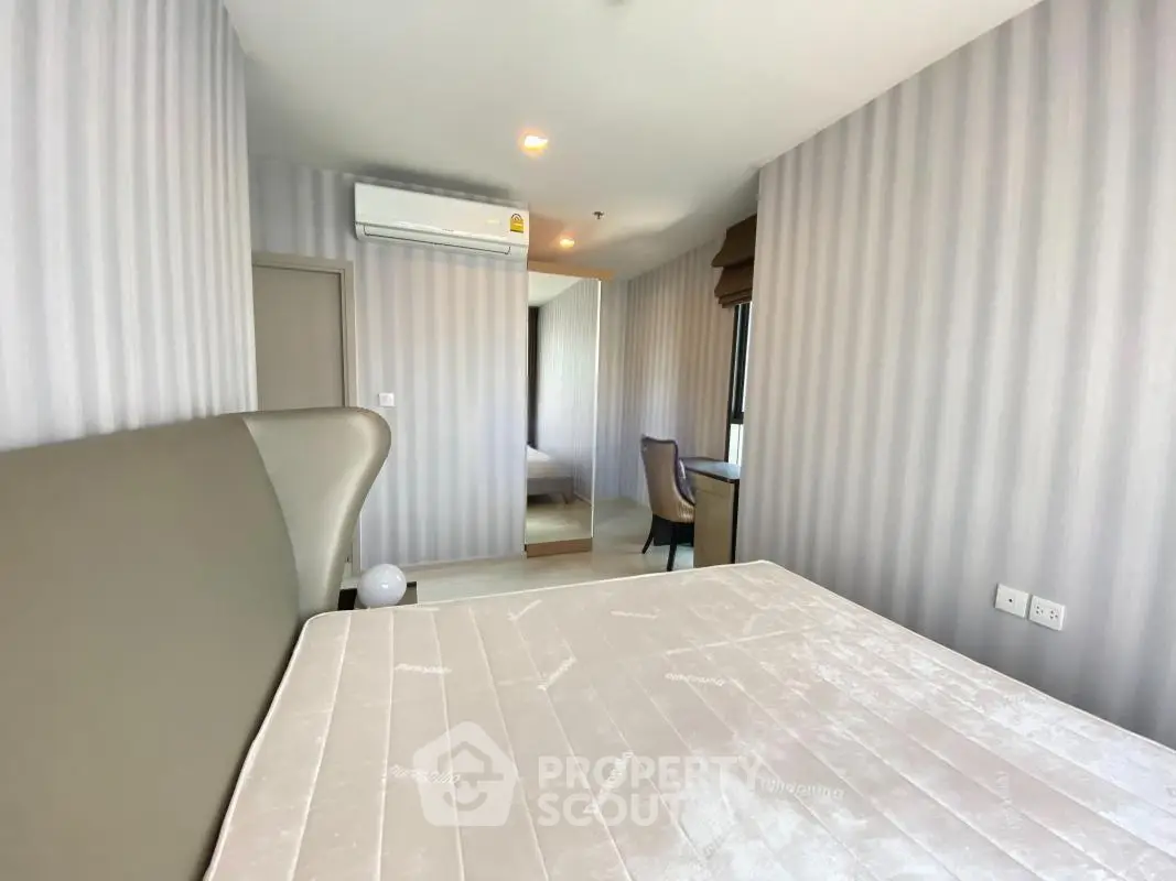 Modern bedroom with stylish decor and large mirror in a contemporary apartment.