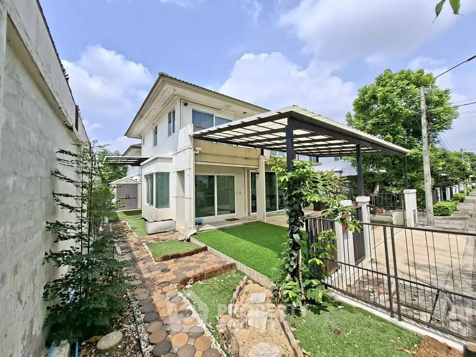 Charming two-story house with lush garden and modern patio in a serene neighborhood.