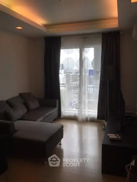 Modern living room with stylish furniture and large window offering city view.