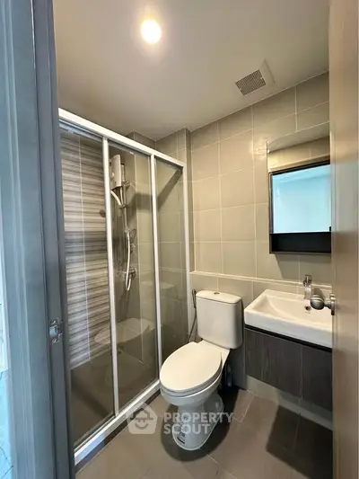 Modern bathroom with glass shower and sleek fixtures in a contemporary apartment.
