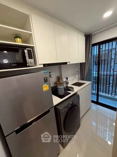 Modern kitchen with sleek appliances and balcony view