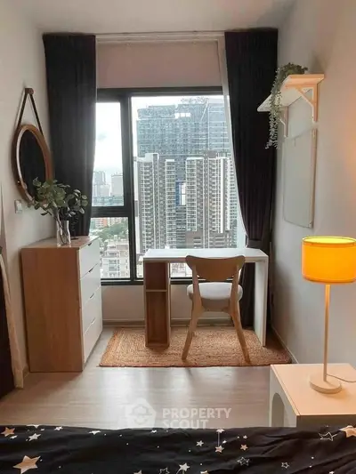 Modern bedroom with city view, stylish desk, and elegant decor in high-rise apartment.