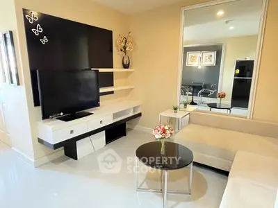 Modern living room with sleek TV unit and cozy seating area, perfect for relaxation and entertainment.