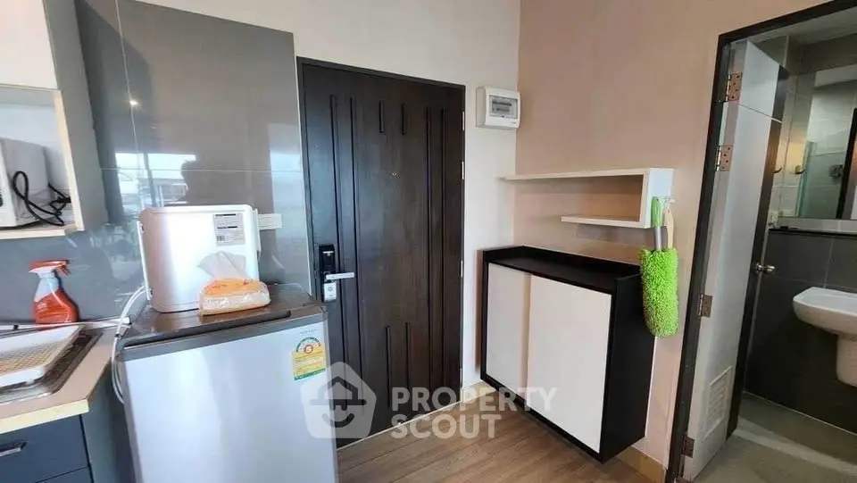 Compact kitchen area with modern appliances and bathroom access