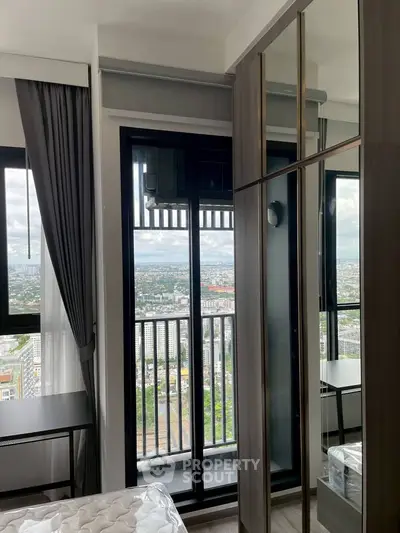 Modern bedroom with balcony and stunning city view, featuring sleek wardrobe and stylish decor.