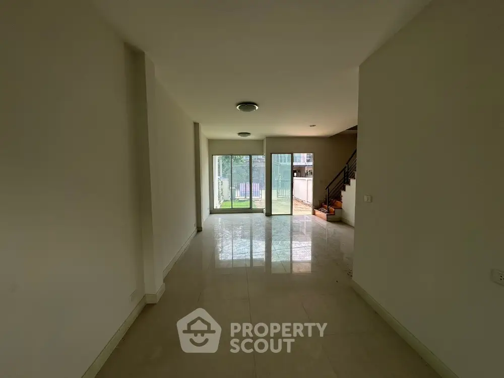Spacious empty living room with large windows and garden view
