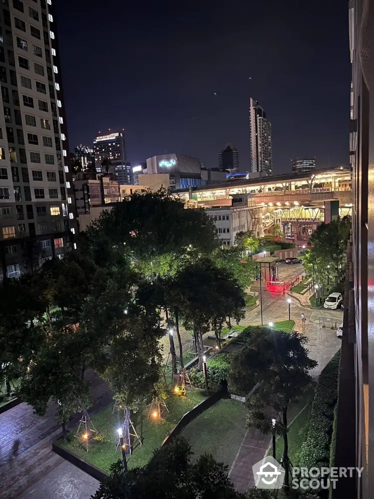 Stunning night view of urban residential complex with lush gardens and city skyline.