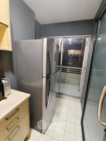 Modern kitchen with stainless steel fridge and balcony access