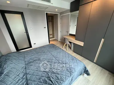 Modern bedroom with sleek design, featuring a cozy bed, built-in wardrobe, and stylish desk area.