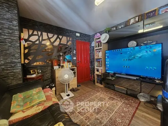 Cozy living room with modern decor, large TV, and stylish partition wall.