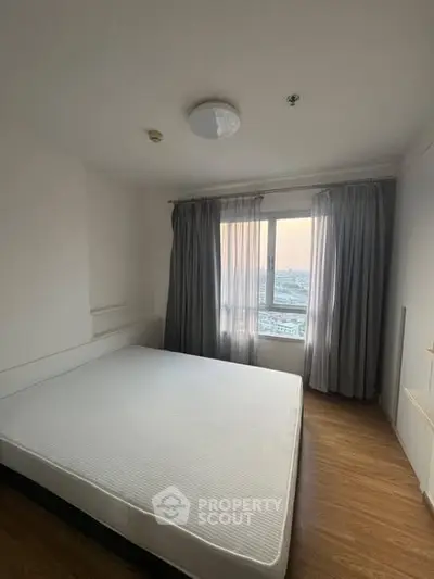 Spacious bedroom with large window and modern decor