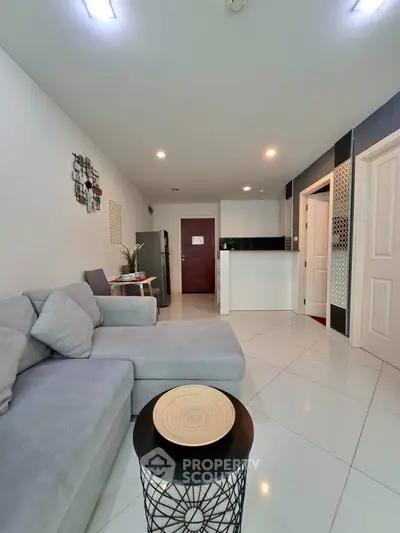 Modern living room with sleek furniture and open kitchen layout in a stylish apartment.