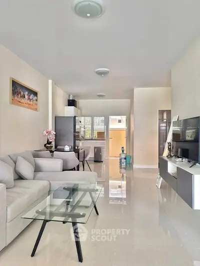 Spacious modern living room with sleek furniture and open kitchen layout