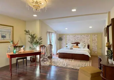 Luxurious bedroom with elegant decor and spacious layout, featuring a chandelier and stylish furnishings.