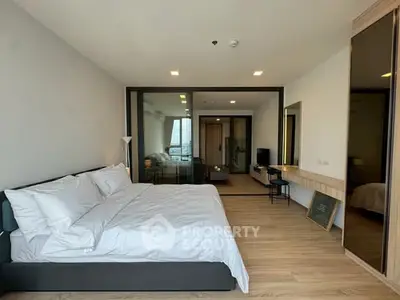 Spacious modern bedroom with large bed and stylish decor in a contemporary apartment.