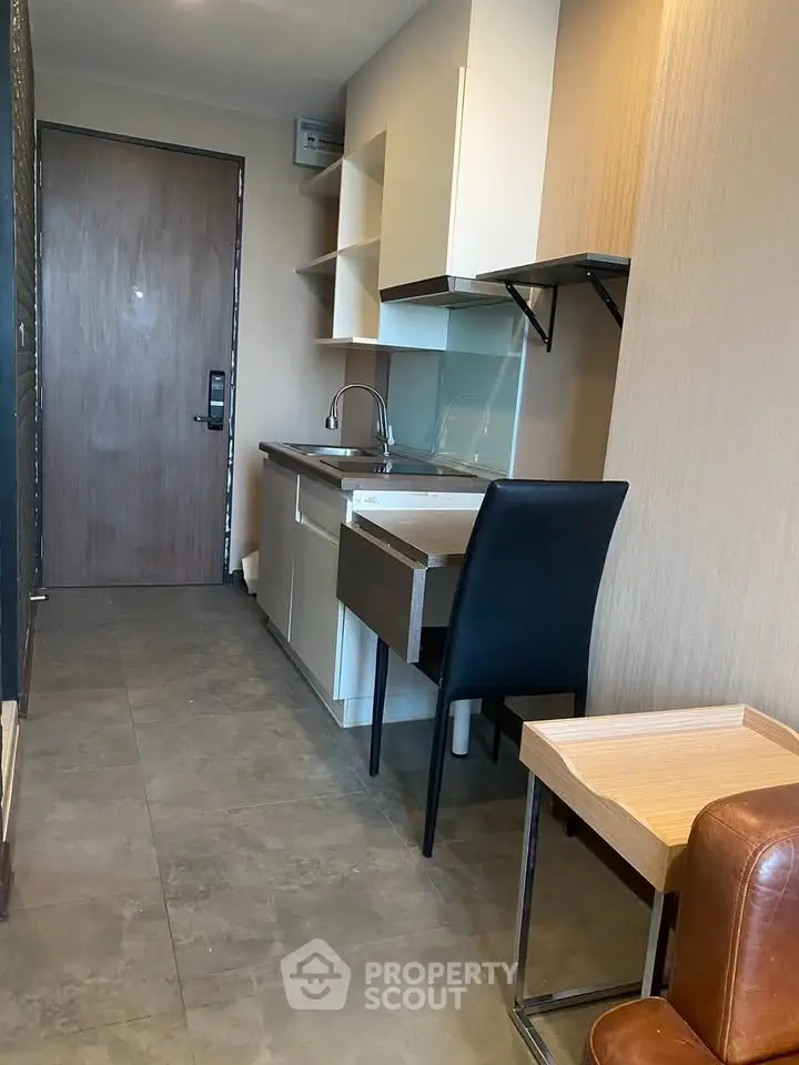 Compact modern kitchen with sleek cabinetry and integrated appliances in a cozy apartment setting.