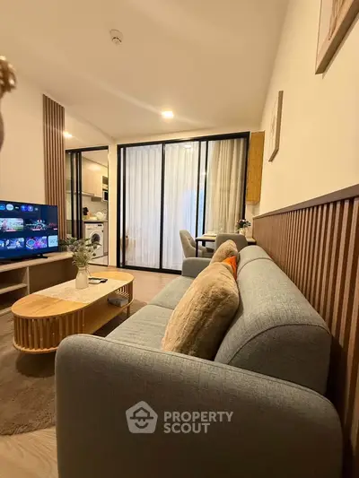 Modern living room with cozy sofa and stylish decor in open-plan apartment.