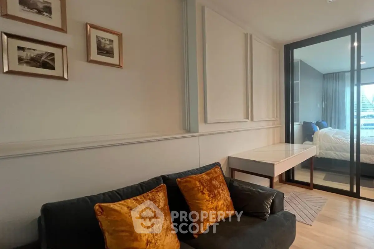 Modern living room with elegant decor and cozy seating adjacent to a stylish bedroom.