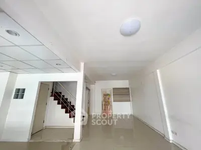 Spacious open-plan interior with tiled flooring and staircase, ideal for modern living.