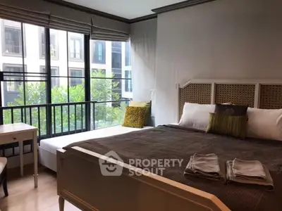 Spacious bedroom with large windows and modern decor in a stylish apartment.