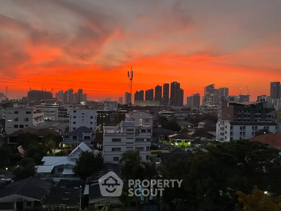 Stunning cityscape view at sunset with vibrant orange sky and modern skyline.