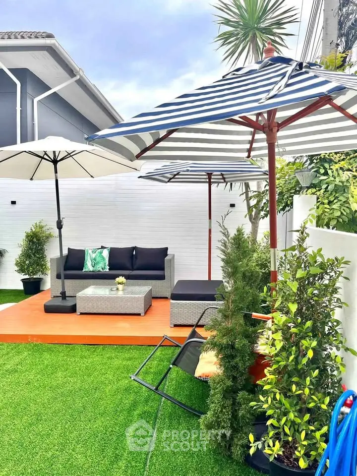 Charming garden with stylish outdoor seating and umbrellas, perfect for relaxation and entertaining.
