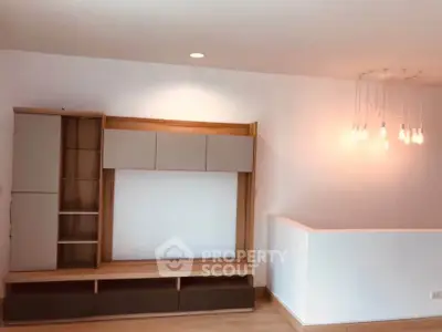 Modern living room with sleek wooden shelving and stylish lighting, perfect for contemporary living.