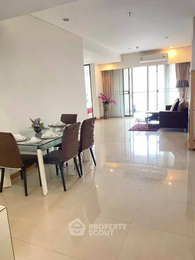 Spacious open-plan living and dining area with modern furnishings and natural light.