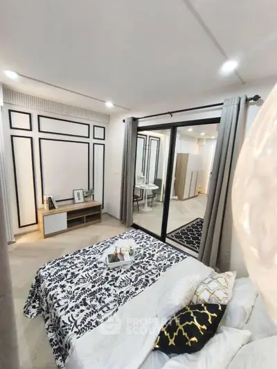 Stylish modern bedroom with elegant decor and sliding glass doors leading to a chic study area.