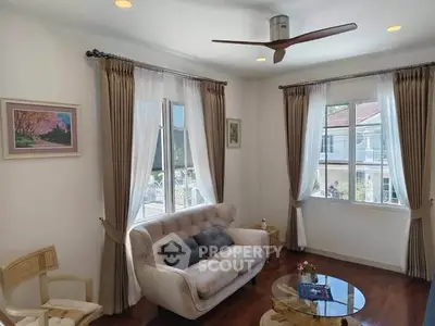 Charming living room with elegant decor, large windows, and cozy seating, perfect for relaxation and entertaining.