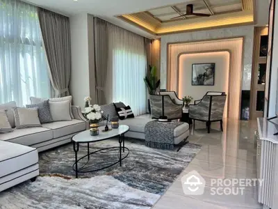 Luxurious living room with elegant furniture, polished marble flooring, and sophisticated ceiling design, bathed in natural light from large windows.